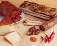 Variety of products containing chili pepper produced in Calabria, southern Italy, on wood background.