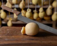 Sliced head of Italian hard cheese Scamorza or Caciocavallo with lime. caciocavallo - Italian cheese made from cow's or sheep's milk, closeup.